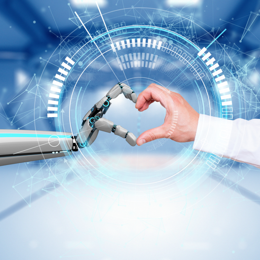Robot and human hands joined together to form the shape of a heart.